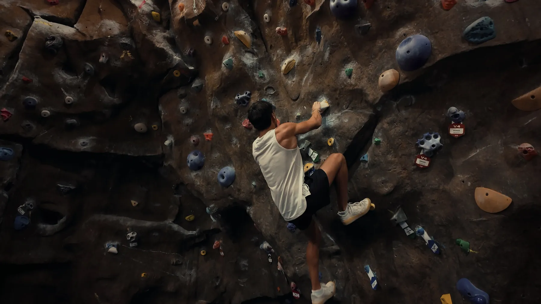 Brennan Harmatz climbing a bouldering wall, seen from above