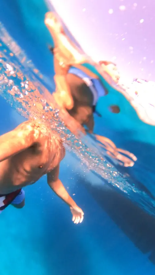 Brennan Harmatz diving underwater in bright blue water