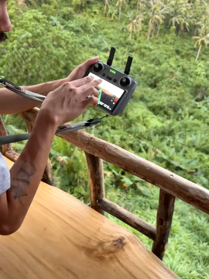 Brennan Harmatz flying a drone over the jungle from a balcony