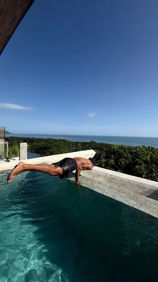 Brennan Harmatz lying on the edge of an infinity pool