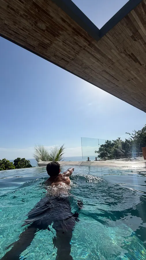 Brennan Harmatz swimming in an infinity pool above the jungle