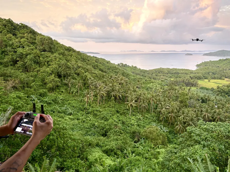 Brennan Harmatz flying a drone over a tropical coastline in the Philippines