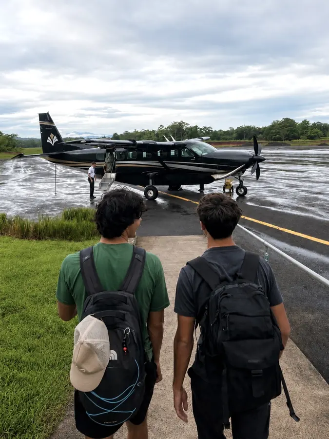 Brennan Harmatz and a friend walking toward a small plane on a tropical runway