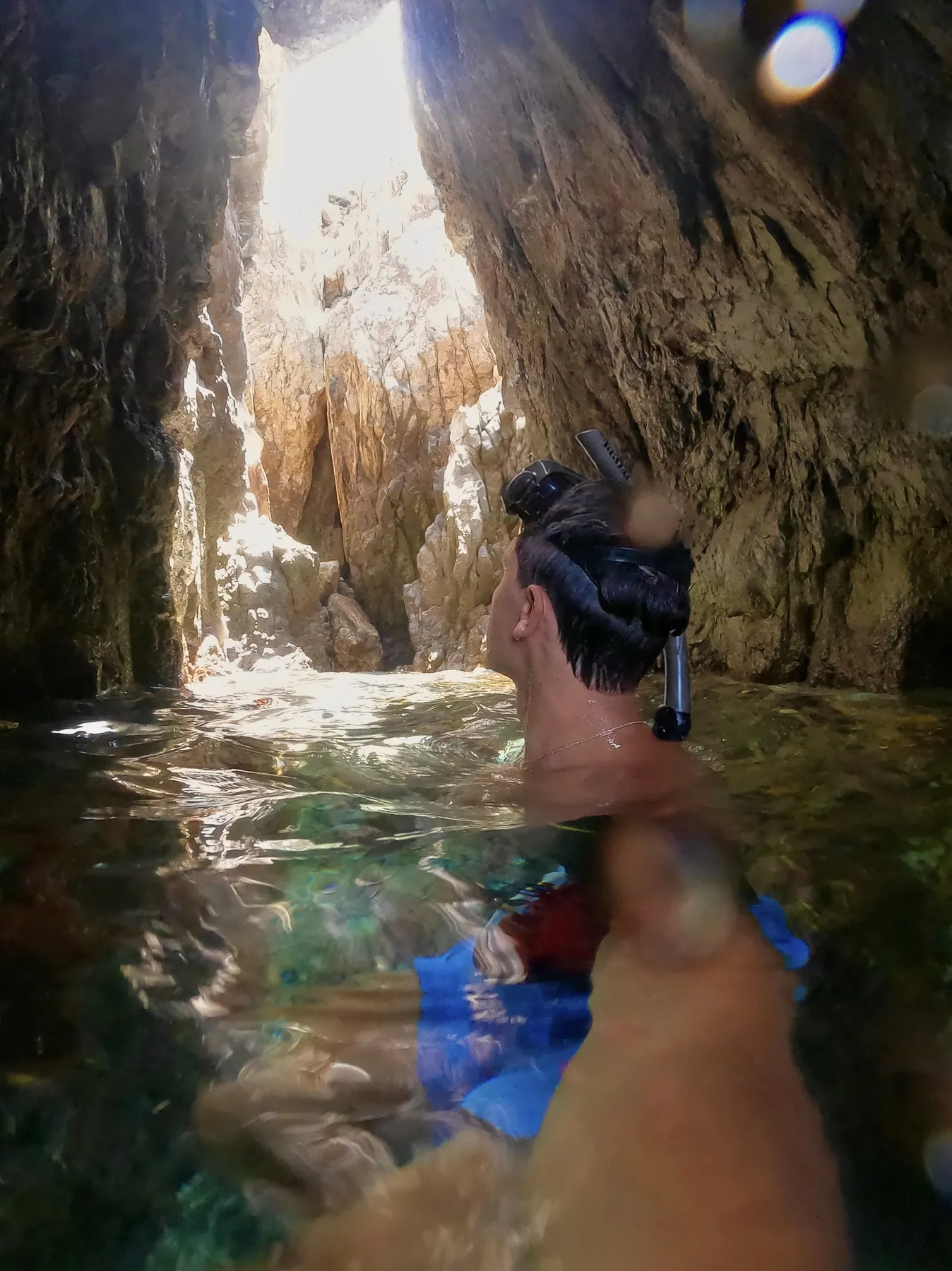 Brennan Harmatz snorkeling in a sea cave lit from above